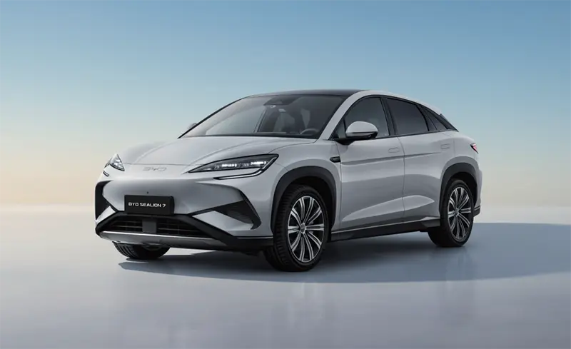 BYD Sealion 7 electric SUV in silver shown from a three-quarter front angle, highlighting its sharp LED headlamp signature and aerodynamic multi-spoke wheels