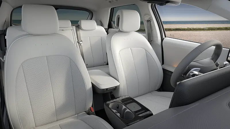 Rear-seat view of IONIQ 5 cabin with white fabric seats and flat floor showcasing spacious interior volume