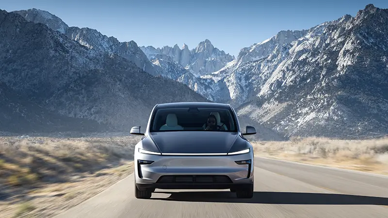 Tesla Model Y in motion on mountain highway showcasing dynamic driving performance and handling capability