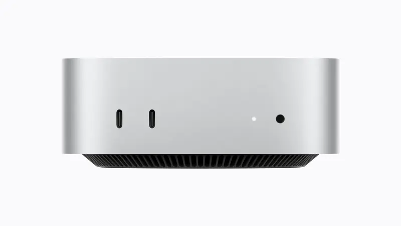 Straight-on front view with two USB-C ports, an indicator light, a headphone jack and the vent ring on the Mac mini M6